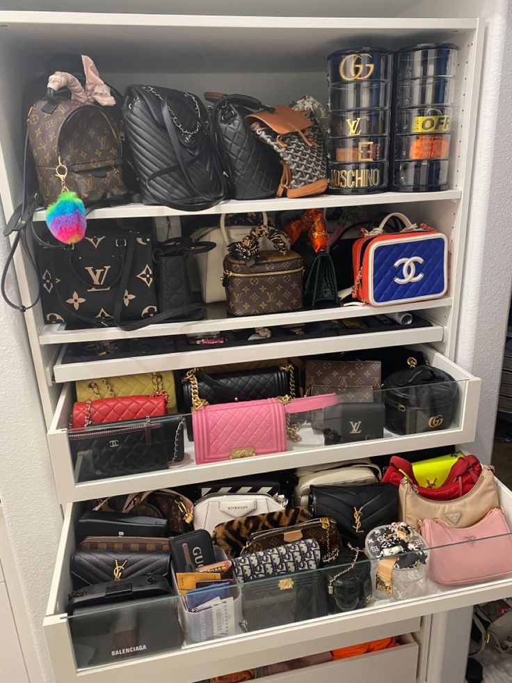 a closet filled with lots of purses and handbags on top of white shelves