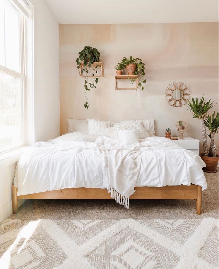 a bed room with a neatly made bed and potted plants