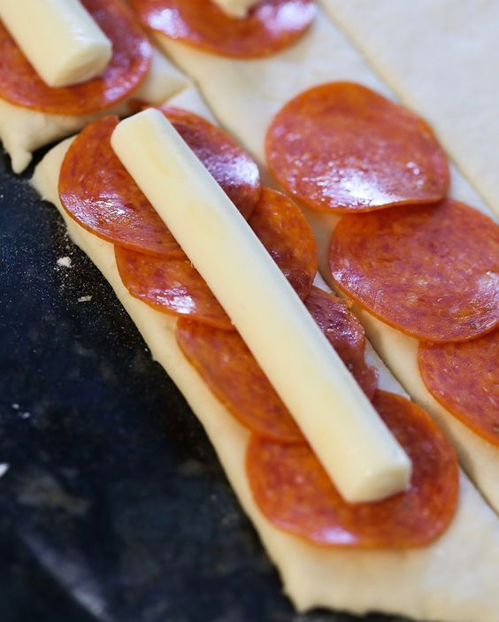 four slices of pepperoni and cheese are arranged on top of each other in rows