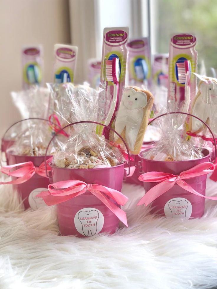 some toothbrushes in pink baskets on a table