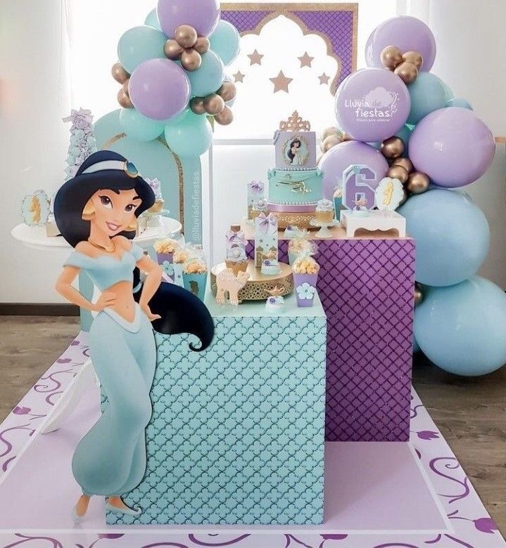 a little mermaid birthday party with balloons, cake and desserts on the table in front of it