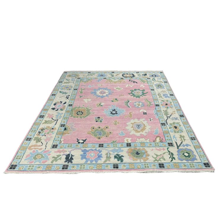 a pink and blue rug with floral designs on the bottom, in front of a white background