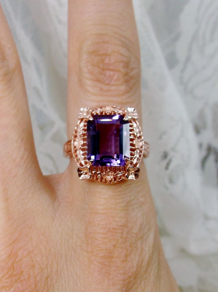 Natural Purple Amethyst Rose Gold plated Sterling Silver RingPicture Frame Design#D227 Inspired by Victorian era designs, this is a lovely reproduction ring. This lovely filigree handcrafted sterling silver ring is overlaid with rose gold plating. This flawless 5 carat Natural Purple Amethyst is 11mm x 9mm. The ring is 11/16" (17.5mm) North to South on the finger. The inside of the band is marked 925 for sterling silver. Notice the beautiful daisies on the outside of the setting and band. There Intricate Rose Gold Sterling Silver Jewelry, Fine Jewelry Amethyst Ring With Intricate Design For Anniversary, Classic Amethyst Rose Gold Jewelry, Elegant Amethyst Ring In Rose Gold For Anniversary, Classic Rose Gold Amethyst Jewelry, Classic Rose Gold Amethyst Rings, Elegant Rose Gold Amethyst Ring With Birthstone, Elegant Rose Gold Amethyst Birthstone Ring, Victorian Amethyst Ring With Center Stone As Gift