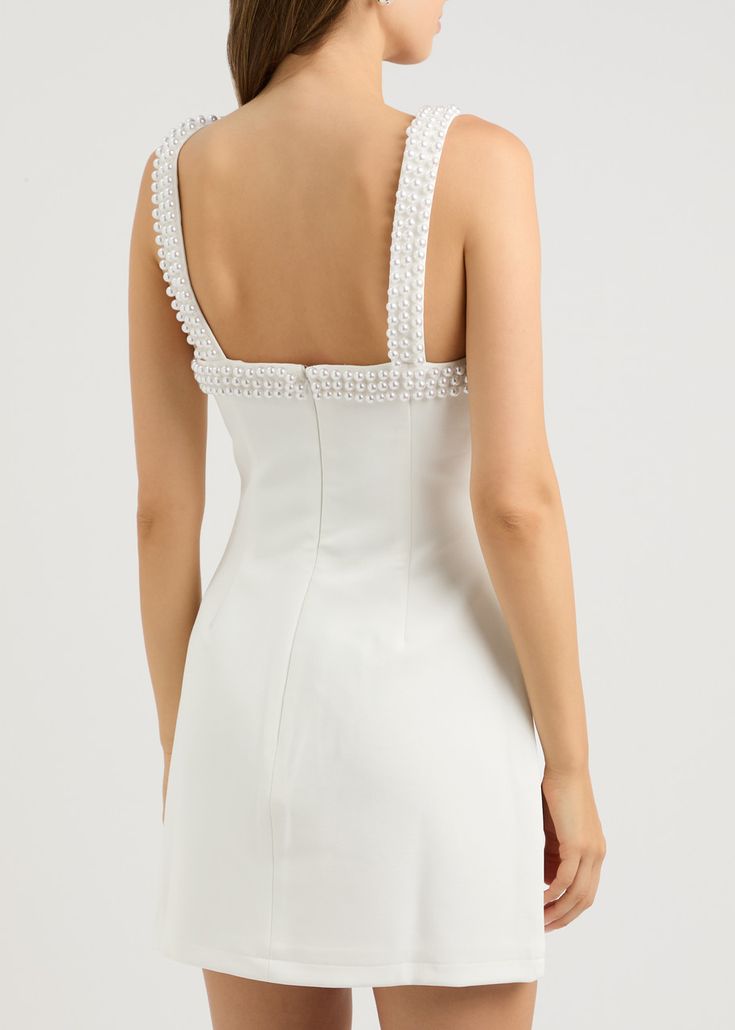 a woman wearing a white dress with an open back