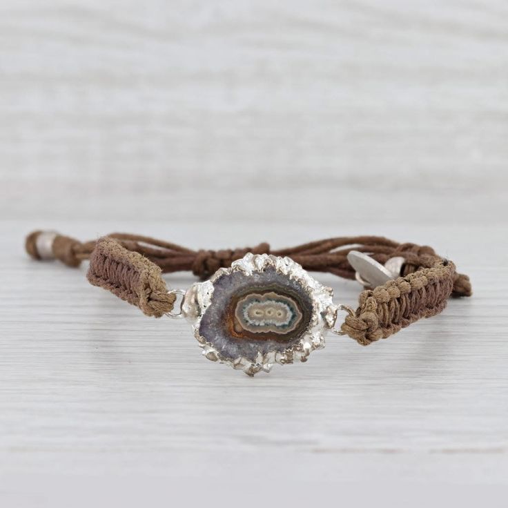 This lovely new bracelet is an authentic Nina Nguyen piece. This bracelet has a retail price of $195. Gem: Marbled Brown Geode Quartz Metal: Silver Toned Weight: 5.6 Grams  Stamps: Nina Nguyen Style: Brown woven chord with center charm Closure: Adjustable Drawstring Inner Circumference: 6"- 9 1/2" Width: 6.5 mm Charm: 16.7 x 26 mm Each piece is thoroughly examined and refinished as needed by our professional jewelers, graded by our in-house GIA (Gemological Institute of America) Graduate Gemolog Adjustable Artisan Sterling Silver Beaded Bracelets, Artisan Adjustable Bangle Bracelets, Adjustable Artisan Jubilee Bracelet, Adjustable Bohemian Sterling Silver Bracelet Gift, Adjustable Bohemian Sterling Silver Bracelet For Gifts, Bohemian Bangle Jewelry With Sliding Knot, Bohemian Adjustable Jubilee Bracelet, Adjustable Artisan Sterling Silver Bangle Bracelet, Adjustable Silver Leather Bracelet Hand Wrapped