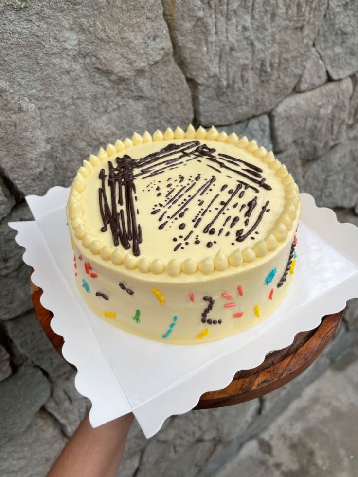 a cake with white frosting and chocolate sprinkles