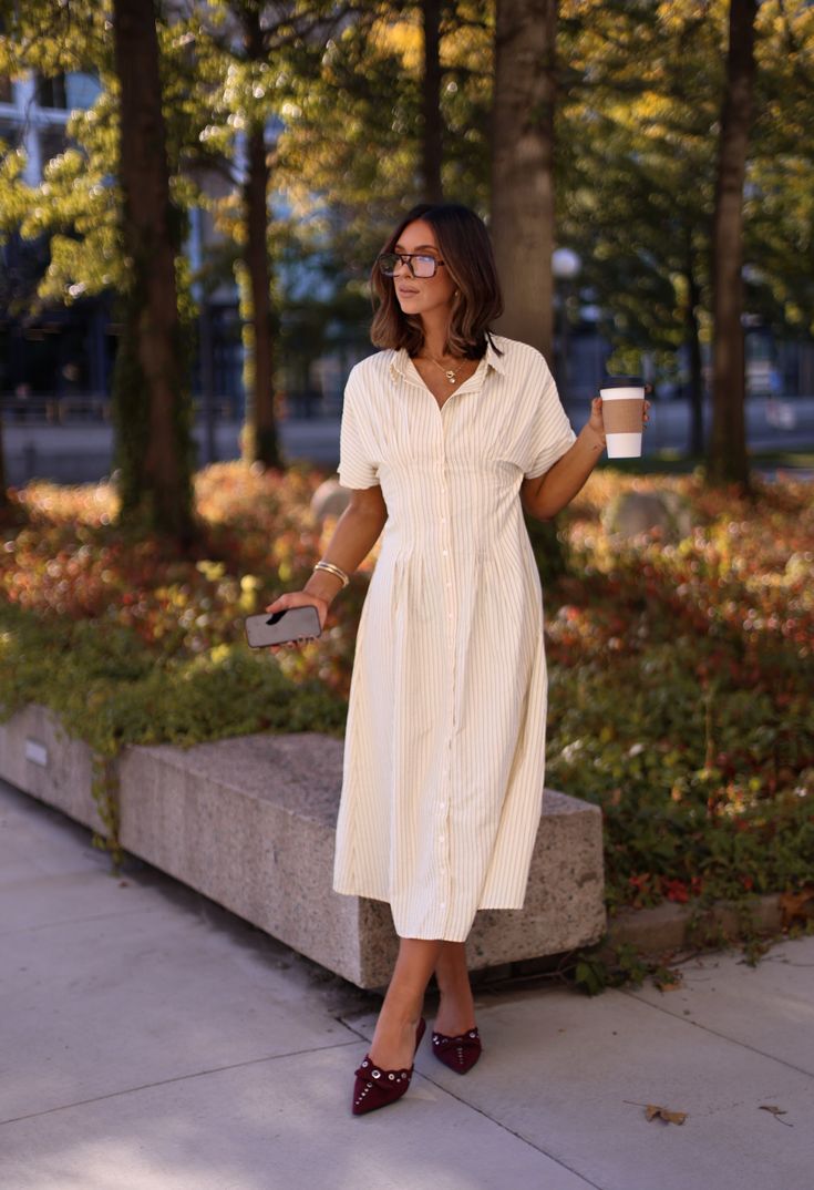 This teacher-inspired dress boasts vertical stripes for a slimming effect, making it an ideal wardrobe choice. The button-down design exudes a classic elegance while the maxi length offers a sophisticated flair. Show off your sense of style with this stylish and flattering dress. Fabric 50% cotton, 50% polyester Casual Striped Maxi Dress For Work, Elegant Striped Maxi Dress For Daywear, Striped Maxi Dress For Workwear In Spring, Spring Striped Maxi Dress For Work, Vertical Stripes Maxi Dress For Day Out, Classic Striped Summer Dress, Short Sleeve Dresses With Vertical Stripes For Work, Chic Vertical Stripes Dress For Day Out, Chic Maxi Dress With Vertical Stripes