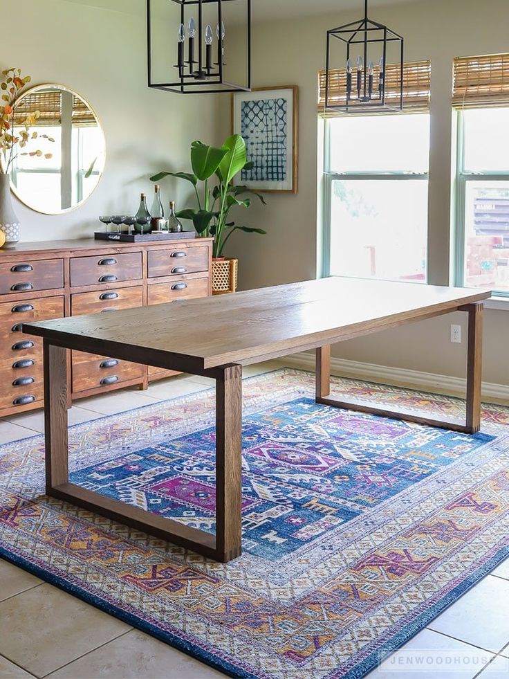 a large wooden table sitting on top of a rug