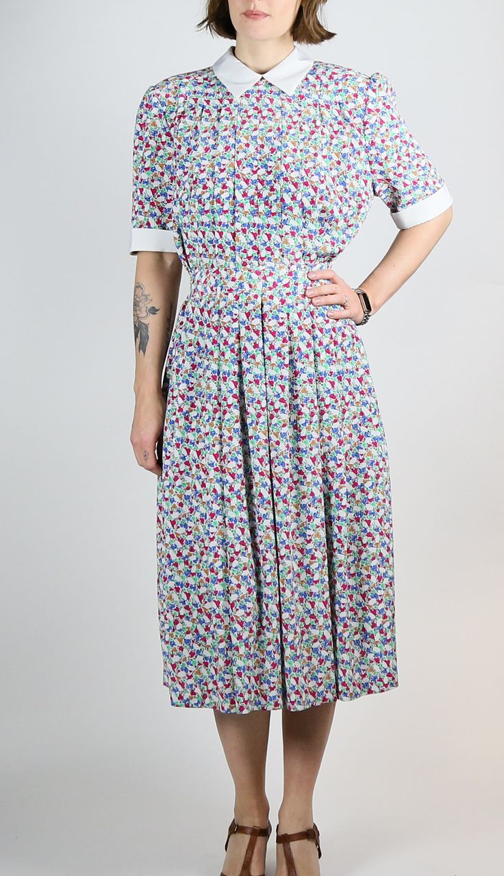 "Women's Vintage Mark Shaw Midi Dress | Button Up | Collared | Pleated Skirt Description Gorgeous mid length dress with darting at front! Features - Fitted waist - Button up back with zipper below waist - Elasticated waist - Pleated skirt - Darting at top Imperfections - none to note Material - Polyester Brand - Mark Shaw Size -  labelled size 10 Measurements lying flat Waist - 37-41cm Bust - 50cm  Length - 117.5cm  Sleeve Length - 30cm Model usually wears size 6-8 and measures Waist - 62cm Hips - 82cm Bust - 86cm Height - 5\"9\" This is a vintage item inspected in Melbourne, Australia. Items have been washed and cared for. Please note, this is not a new item and whilst careful attention has been paid to any flaws and damage, there may be something that we've missed. Please get in touch if A-line Midi Dress With Buttons For Garden Party, Short Sleeve Dresses With Button Closure For Garden Party, Casual Short Sleeve Maxi Dress With Button Closure, Multicolor Buttoned Dress For Garden Party, A-line Dress With Button Cuffs For Daywear, A-line Dresses With Button Cuffs For Daywear, Midi Length Dress With Covered Buttons For Daywear, Multicolor Button-up Daywear Dress, Daywear Midi Dress With Button Closure