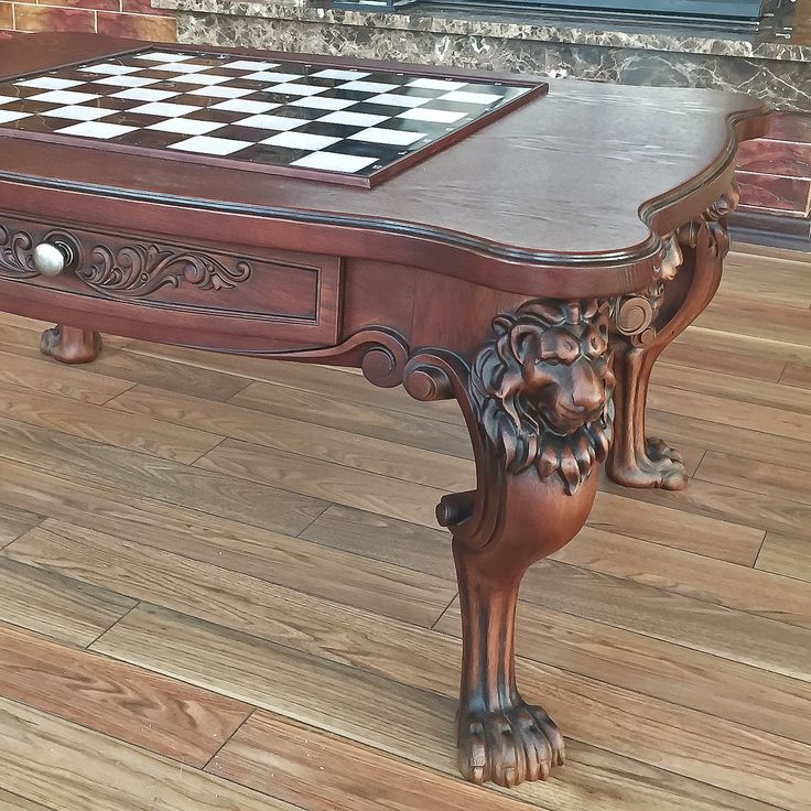 a wooden table with a checkerboard board on it's top and lion legs