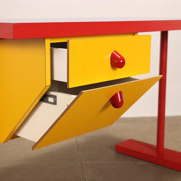 a yellow and red desk with two drawers on each side that is open to reveal a file cabinet