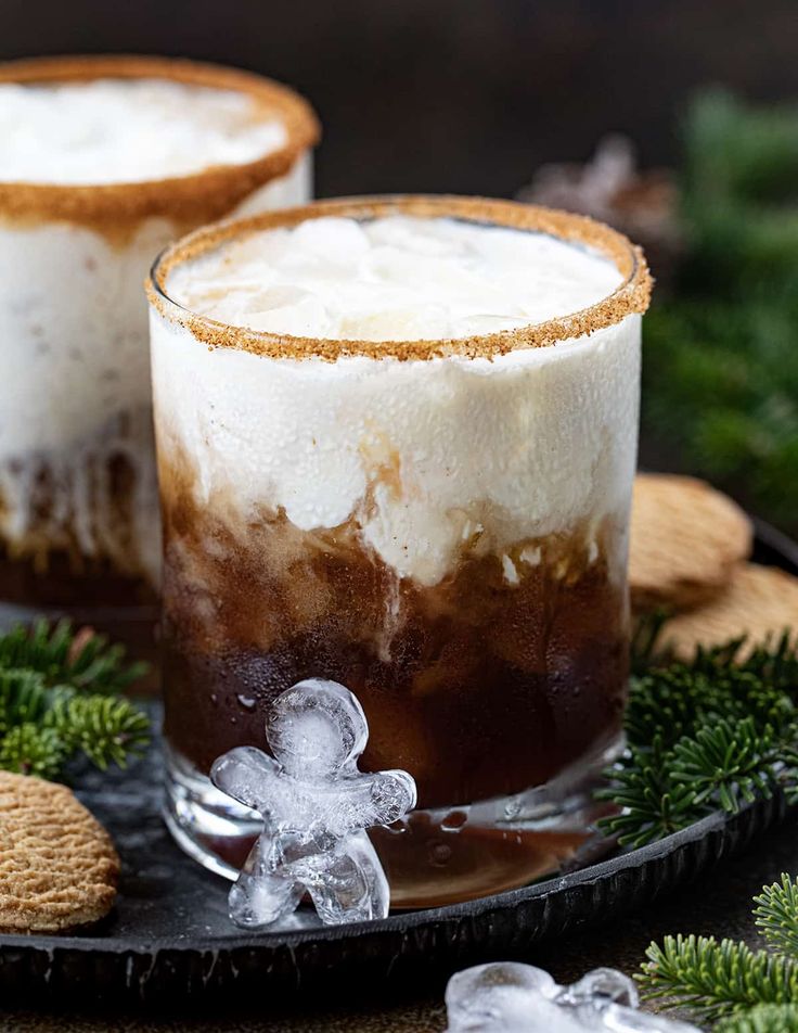 two glasses filled with ice cream on top of a black plate