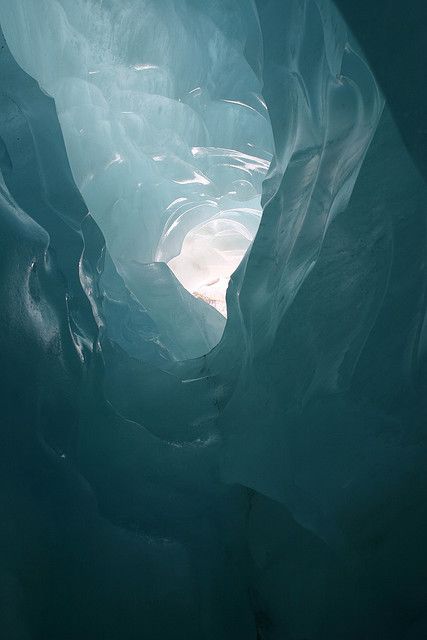 the inside of an ice cave with light coming through