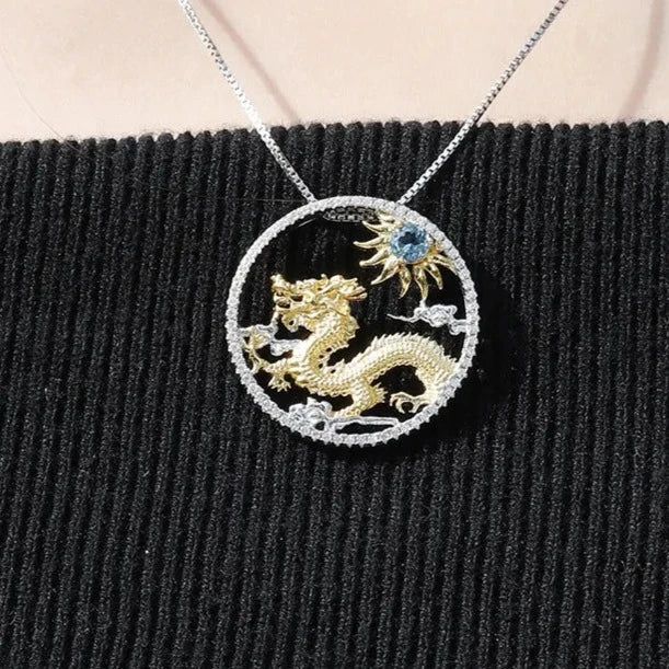 "Embark on a journey of mythical elegance with our sterling silver and gold necklace, featuring the majestic Chinese zodiac dragon alongside a radiant sun centerpiece adorned with your choice of blue topaz, diopside, or opal gemstones. 🐉🌞✨ This enchanting piece blends ancient symbolism with modern sophistication, capturing the essence of strength, power, and celestial beauty. Meticulously crafted with intricate detailing, the dragon symbolizes courage and wisdom, while the sun represents vital Yellow Gold Dragon Pendant Jewelry, Yellow Gold Dragon Design Pendant Jewelry, Luxury Gold Dragon Design Jewelry, Luxury Gold Jewelry With Dragon Design, Elegant Diamond Sun And Moon Jewelry, Elegant Diamond Jewelry With Sun And Moon Design, Spiritual Sterling Silver Jewelry With Dragon Design, Gold Dragon Design Jewelry, Yellow Gold Dragon Design Jewelry Gift