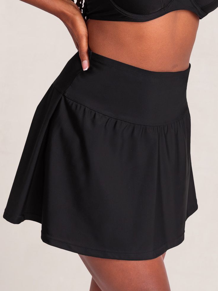 Your sunny adventure sidekick, Shapermint Essentials High Waisted Full Coverage Swim Skirt gives you the full-coverage confidence and flattering fit you deserve. Take this versatile flounce skirt style from brunch to the beach. Its wide and high-profile waistband smooths your midsection, and its built-in bikini bottom delivers maximum comfort. Pair this skirt with the Shapermint Essentials Full Coverage Halter Bikini Top and your outfit is complete! Wide Waist Band for Smoothing No Muffin Top Fl Flowy Swim Skirt With Built-in Shorts, Black Skirt With Built-in Shorts For Beach, Stretch Solid Pleated Swim Skirt, Stretch Solid Color Pleated Swim Skirt, Stretch Pleated Solid Color Swim Skirt, Casual Pleated Skirted Swim Skirt, Solid Tennis Skirt With Elastic Waistband, High-waist Skirt With Built-in Shorts, Solid Color Tiered Skort With Lined Skirt