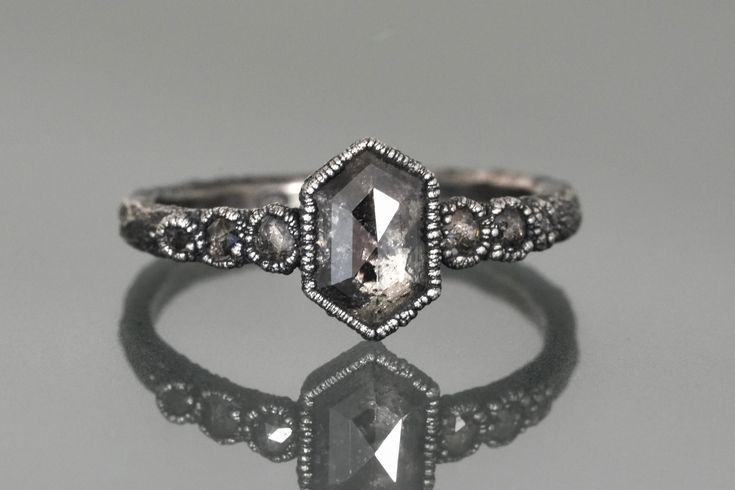 an antique style engagement ring with a diamond in the center and two diamonds on each side