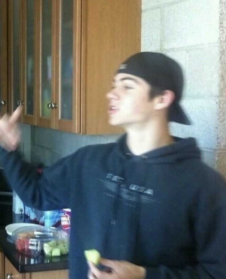 a young man standing in front of a kitchen counter