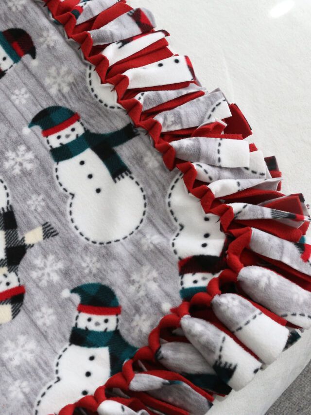 a close up of a snowman blanket on a bed