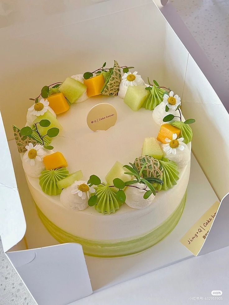 a cake in a box decorated with flowers and leaves