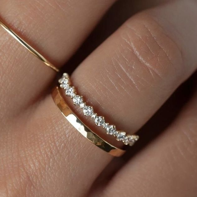 a woman's hand with a gold and diamond ring