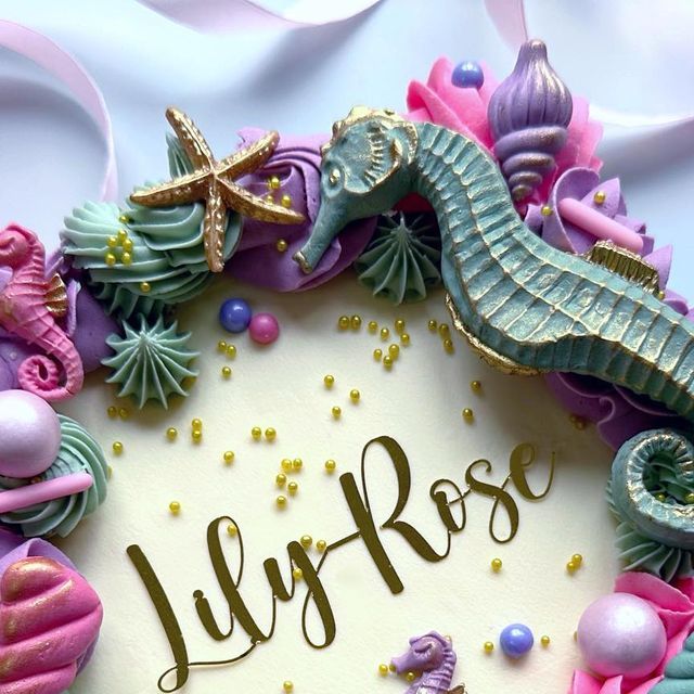 a birthday cake decorated with seahorses and stars