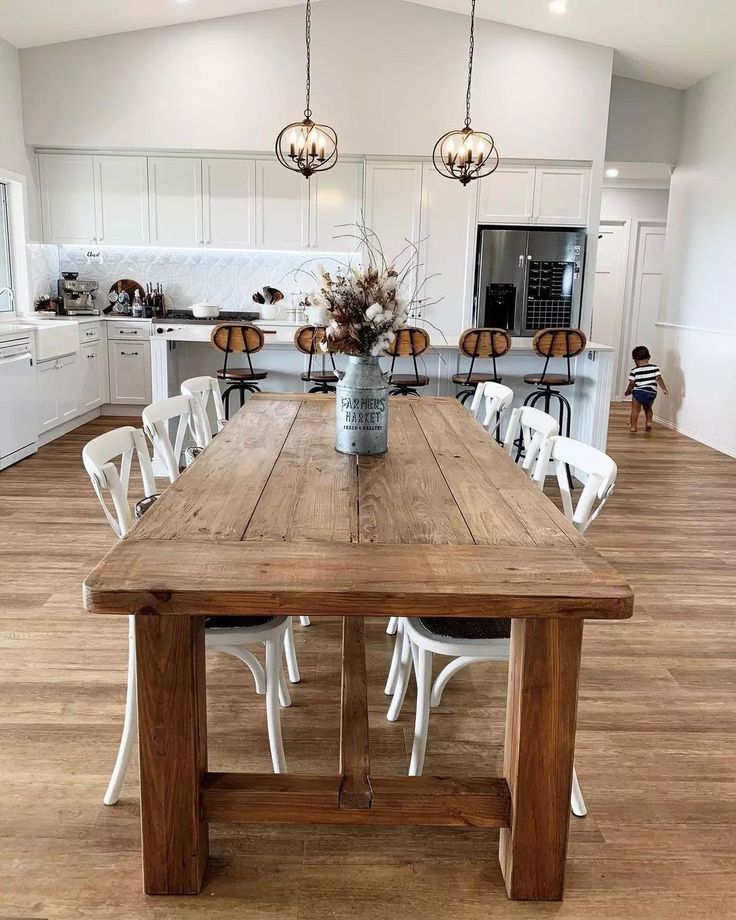 a dining room table with white chairs around it