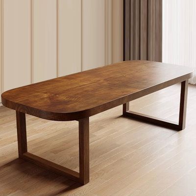 a wooden table sitting on top of a hard wood floor next to a white wall