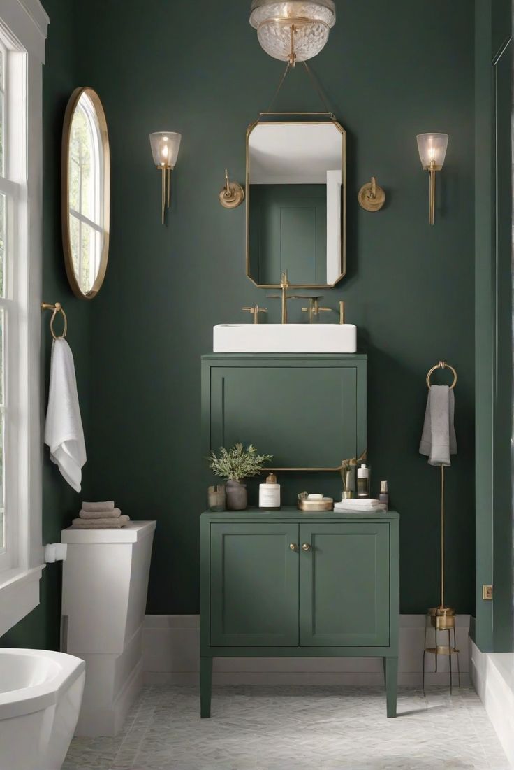 a bathroom with green walls and gold fixtures on the vanity, toilet, sink and mirror