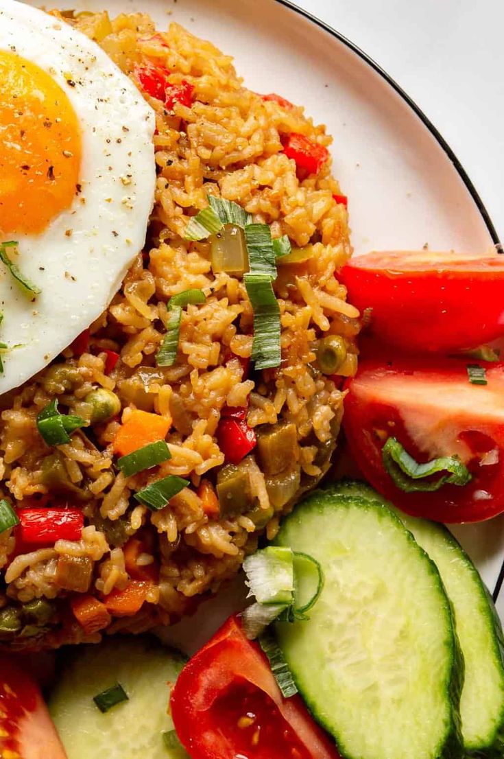 a plate with rice, vegetables and an egg on it that says vegetarian nasi goreng