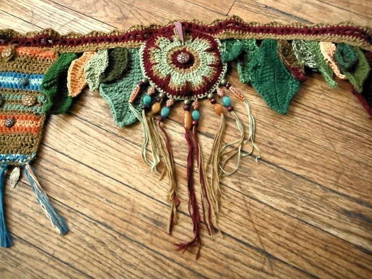 a close up of a piece of cloth on a wooden floor with beads and tassels