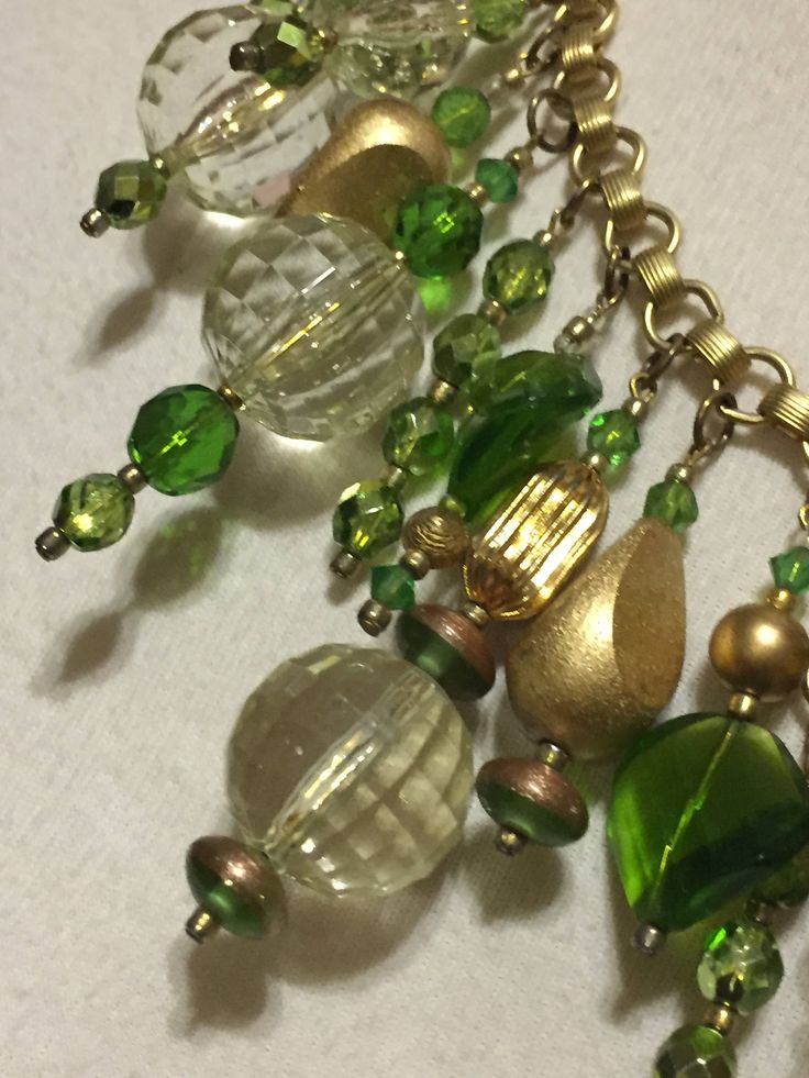 Here is a one-of-a-kind (OOAK) necklace that I made for the holidays. Looks like Christmas balls or Christmas ornaments in shades of green and gold! Materials used were faceted Lucite, painted wooden beads, metallic beads, faceted glass beads, brass beads, fluted beads and more... Vintage and contemporary findings were used to create this statement piece. The necklace looks great on and really captures the light! Perfect for those holiday parties that will be here before you know it! OOAK Green Large Beads Necklace For Party, Green Beaded Dangle Necklaces, Green Dangle Necklace With Beads, Green Necklaces With Dangling Beads, Green Dangle Jewelry With Large Beads, Green Large Beads Party Necklace, Festive Green Beaded Necklace With Dangling Beads, Bohemian Green Jewelry For Holiday, Green Beaded Necklaces With Dangling Beads For Party