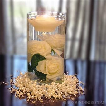 white roses in a glass vase on a table