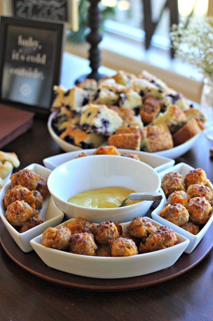 several plates of food on a table with dipping sauce in bowls and pastries to the side