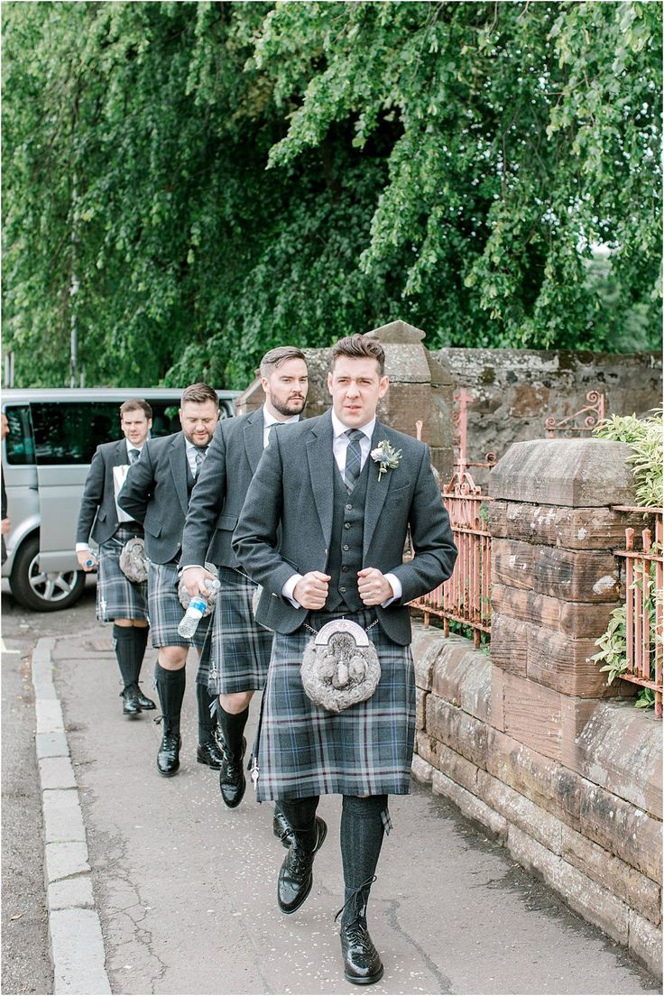 men in kilts are walking down the street