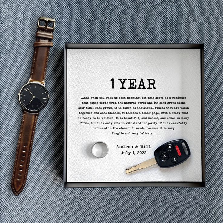 a watch and keys are sitting next to a card with the words 1 year written on it