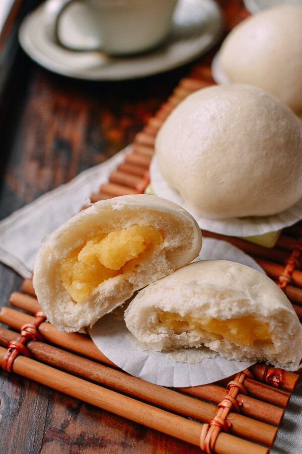 two buns on a bamboo mat with chopsticks next to them