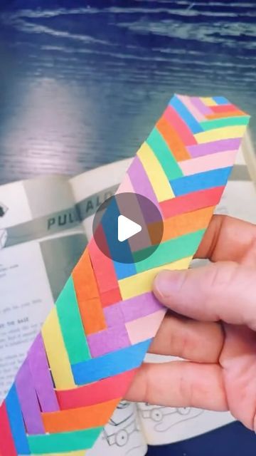 someone is holding a piece of paper that looks like a rainbow colored strip of tape