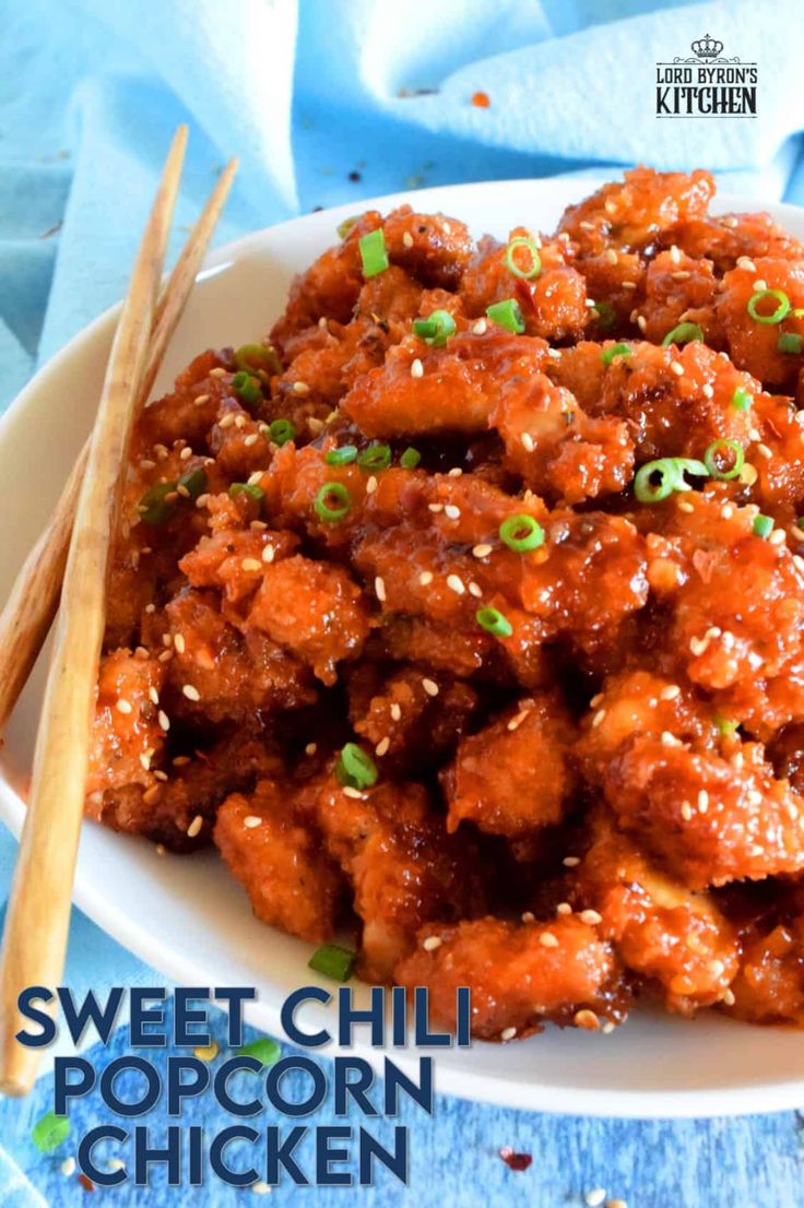 sweet chili chicken with sesame seeds and green onions on a white plate next to chopsticks