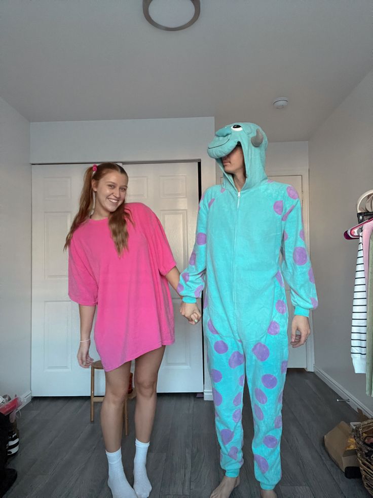 two people dressed in animal onesuits holding hands