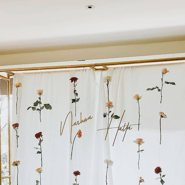 the curtains are decorated with flowers and writing on them, along with gold trimmings