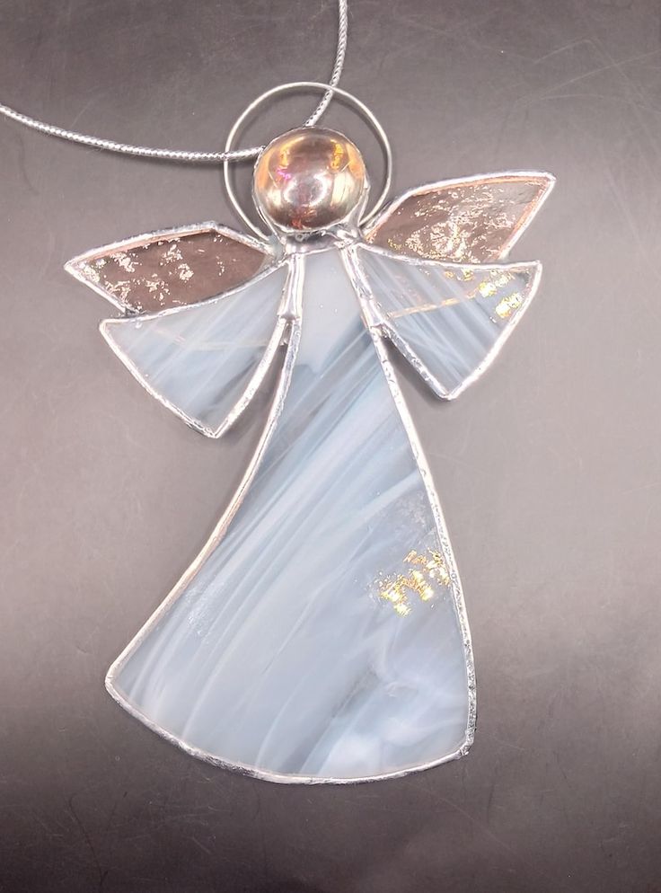 a glass angel ornament hanging from a silver chain