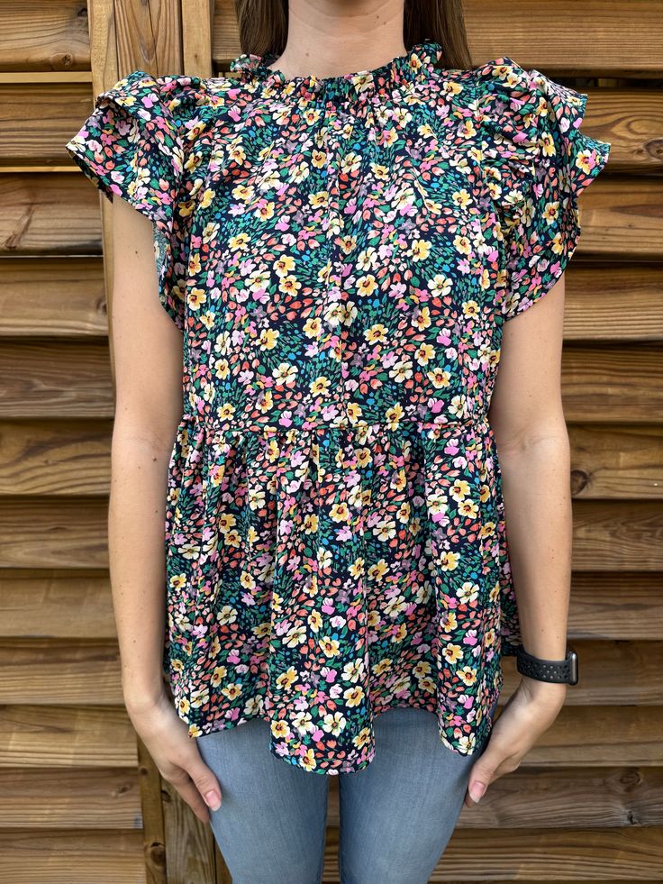 Get ready for the ultimate spring fashion statement with our Spring Has Sprung Navy Mix Floral Blouse! Featuring a vibrant floral print with pops of yellow, pink, orange, green, and blue, ruffled sleeves for a fun and flirty touch, and a high neckline with a button keyhole on the back. Embrace the season with this playful addition to your wardrobe! Color: Navy Mix Model is 5'6", 125 lbs, and is wearing a small! True to Size. Material: 100% Polyester 125 Lbs, Wardrobe Color, Mixed Models, Bootie Sandals, Spring Has Sprung, Ruffled Sleeves, Toddler Tees, Skirt Leggings, Green And Blue