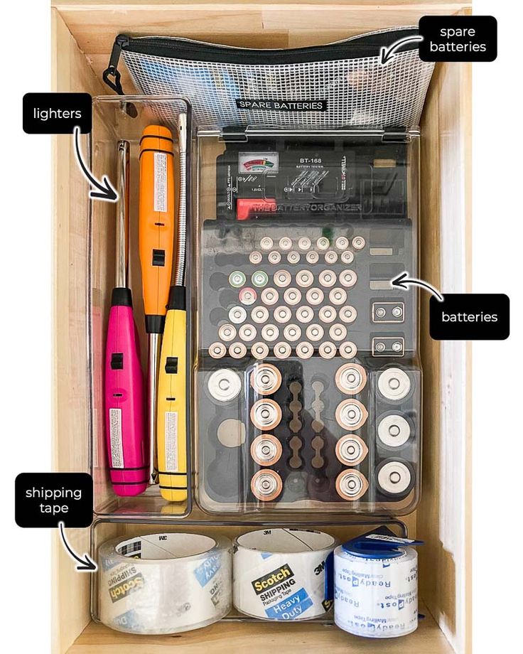 an organized drawer with different types of office supplies and items labeled on the bottom shelf