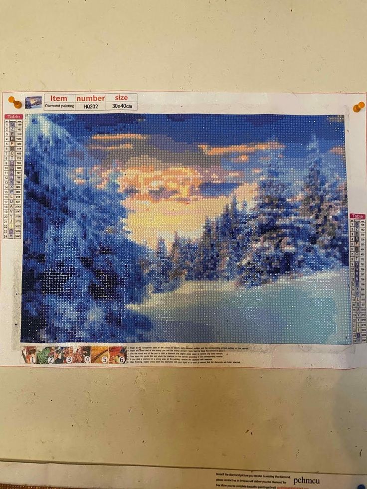 a cross - stitch picture of a snowy landscape with trees and the sun in the distance