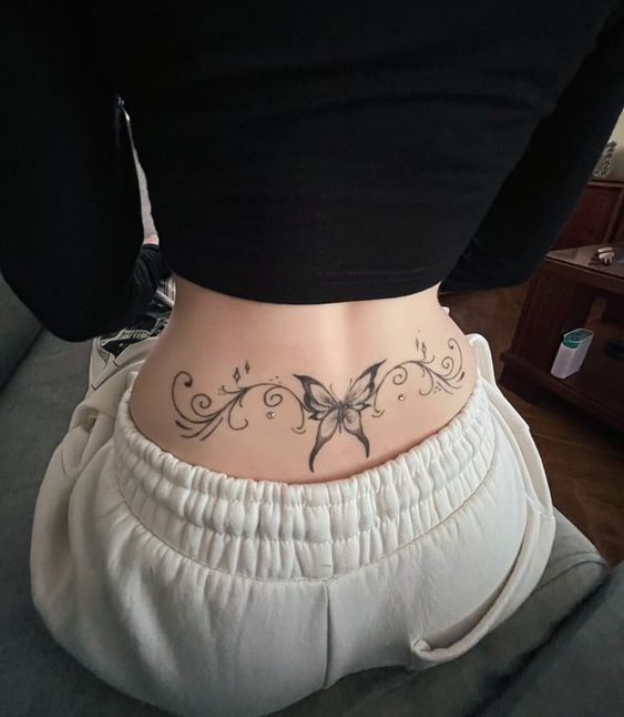 a woman with a butterfly tattoo on her lower back and the bottom part of her stomach