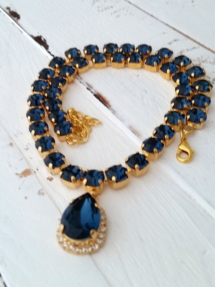 "Navy blue crystal Swarovski necklace, Navy blue, Statement necklace, Bridal necklace, Bridesmaids gift, Tennis necklace,Wedding jewelry Exquisite piece of jewelry!! MADE TO ORDER WITH CUSTOM COLOR STONES AND PALTING. Please contact me. This is a breathtaking sparkly necklace will attract tons of attention. It is made with deep blue teardrop and 8 mm stones. The length of the necklace is 41 cm (16.14 inch) and has an extension chain of 9 cm (3.5 inch) for adjustment. Made with gold plated and Sw Sapphire Crystal Bridal Necklace Gift, Blue Crystal Rhinestone Necklace For Wedding, Elegant Blue Rhinestone Necklace For Wedding, Blue Crystal Necklaces For Wedding, Blue Crystal Bridal Necklace Gift, Blue Crystal Necklace For Wedding, Blue Crystal Bridal Necklace For Gift, Sapphire Jeweled Necklace For Wedding, Sapphire Choker