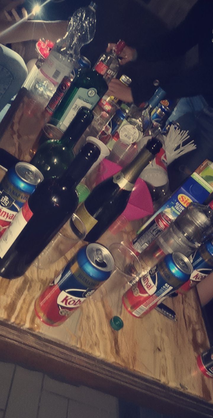 a wooden table topped with lots of bottles and cans