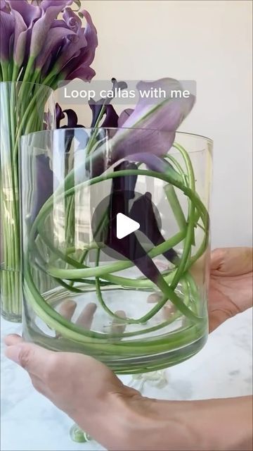 a person holding a vase with purple flowers in it and the caption loop calls with me