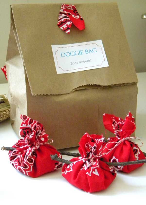 three small red bags sitting on top of a table next to a brown paper bag