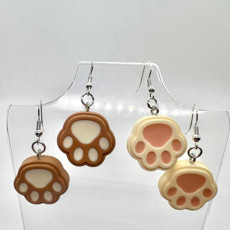 three pairs of earrings with paw prints on them